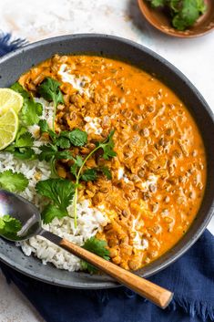 coconut lentil curry in a bowl with rice and cilantro on the side