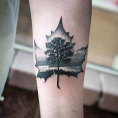 a black and white maple leaf tattoo on the arm