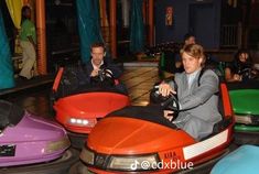 people are riding bumper cars at an amusement park