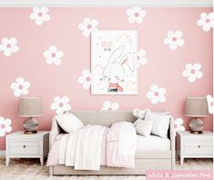 a bedroom decorated in pink and white with flowers painted on the wall behind the bed