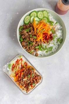 two bowls filled with rice, meat and veggies next to a bottle of juice