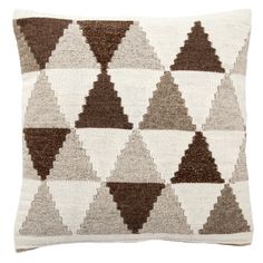 a brown and white pillow with many different shapes on the front, in various colors