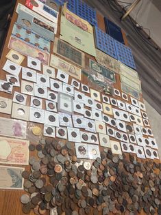 many different types of coins are arranged on a wooden table with papers and magnets