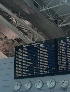 there are many clocks on the wall in this airport terminal area that is displaying departure times