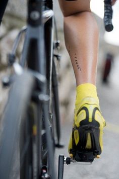 the legs and feet of a person riding a bike with yellow gloves on their feet