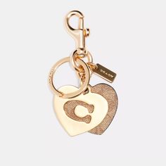 Add A Touch Of Elegance To Your Keys With This Nwt Coach Signature Hearts Key Ring Bag Charm Purse Keychain In Gold/Khaki. The Heart-Shaped Keychain Features The Coach Signature And A Detachable Key Ring, Making It A Versatile Accessory For Everyday Use. Measuring 1.75 Inches In Length And Width, The Keychain Is Made Of Durable Metal And Has A Stylish Design That Fits Any Fashion. Whether You Are A Fan Of The Coach Brand Or Simply Love The Heart Theme, This Keychain Is A Must-Have For Your Colle Metal Heart Keychain, Everyday Bag Charm With Lobster Clasp, Gold Logo Charm Bag Charm, Logo Charm Bag For Everyday Use, Elegant Bag Charm With Logo, Gold Bag Charm With Logo For Everyday Use, Gold Bag Charm With Logo, Coach Gold Heart-shaped Jewelry, Coach Heart-shaped Gold Jewelry