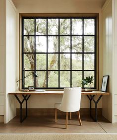 a desk with two chairs and a large window