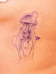 a woman's stomach with a tattoo of a jellyfish