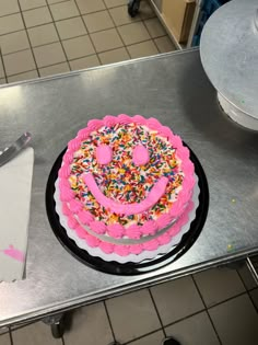 a birthday cake with sprinkles and a smiley face on the top is ready to be cut