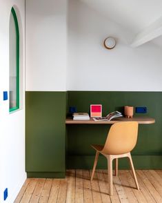 a chair and desk in a room with green walls