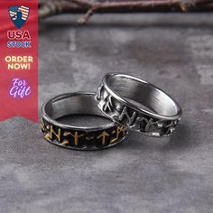 two silver rings with crosses on them are sitting on a gray surface next to an american flag