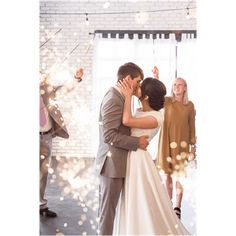 a bride and groom kissing in front of sparklers