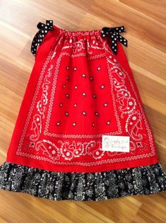 a red skirt with black and white polka dots on the bottom is sitting on a wooden floor