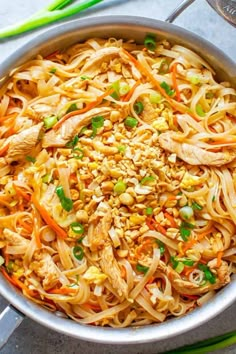 a pan filled with noodles and vegetables on top of a table