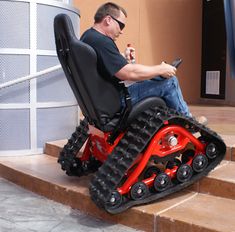 a man in a wheel chair holding a cell phone while sitting on some steps outside