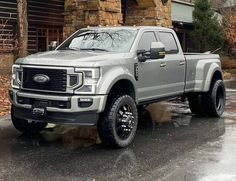 a silver truck parked in front of a log cabin