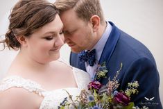 a bride and groom pose for a wedding photo with flowers in their bouquet at the end of their day