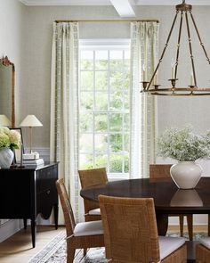 a dining room table with chairs and a chandelier hanging from it's ceiling