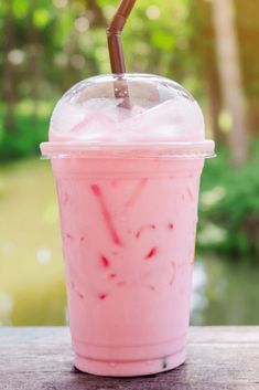 a pink drink sitting on top of a wooden table