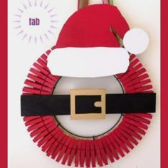 a paper plate with a santa hat on top of it and scissors in the middle