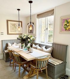 a dining room table and bench with flowers on it