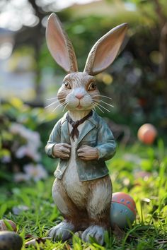 a figurine of a rabbit dressed in a suit and tie standing on some grass