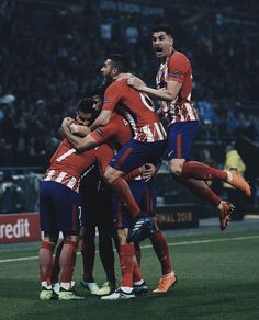 a group of men standing on top of a soccer field