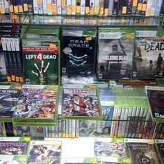 several video games are on display for sale in a game store, including the xbox