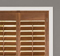 an open window with wooden shutters and blinds