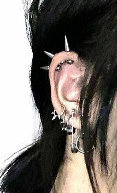 a close up of a person with piercings on their nose and ear rings attached to them