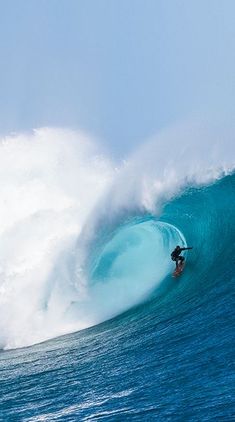 a man riding a wave on top of a surfboard