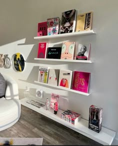 a white chair sitting in front of a shelf filled with books on it's sides