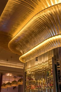 the interior of a restaurant with glass walls and metal ceilinging that is lit up at night