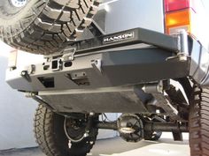 the rear end of a truck with two large tires on it's bumpers