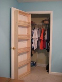 an open closet with clothes hanging in it