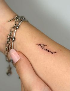 a woman's arm with the word love written on it and a chain around her wrist