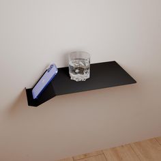 a glass on top of a black shelf