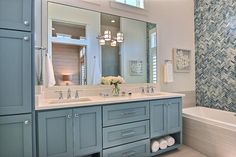 a bathroom with blue cabinets and white fixtures