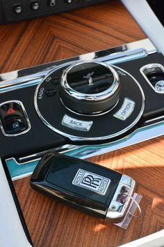 a cell phone sitting on top of a wooden table next to a car charger