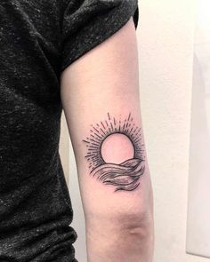 a woman's arm with a sun and waves tattoo on the left inner arm