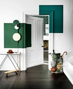 an open door in a white room with green accents