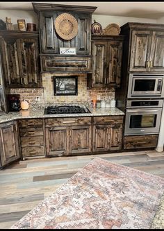 a kitchen with wooden cabinets and an area rug in front of the stove top oven