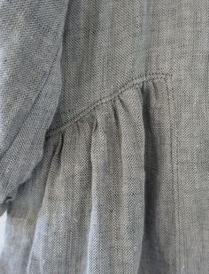 closeup of the back of a dress with pleated sleeves and buttons on it