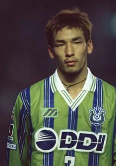 a young man in a green and blue striped soccer jersey with the word pddi on it