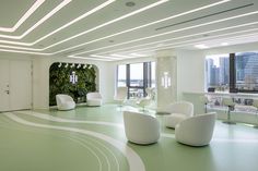 a large room with white chairs and green carpeted flooring, overlooking the city