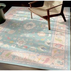 a chair sitting on top of a wooden floor next to a blue and pink rug