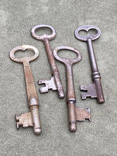 four old keys are laying on the floor