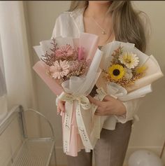 a woman is holding flowers in her hands