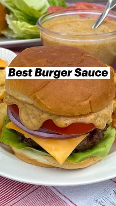 a cheeseburger with onion, lettuce and tomato on a white plate