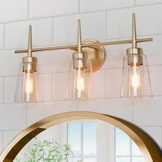 a bathroom vanity light with three lights on the top and one in the middle, against a white tile wall